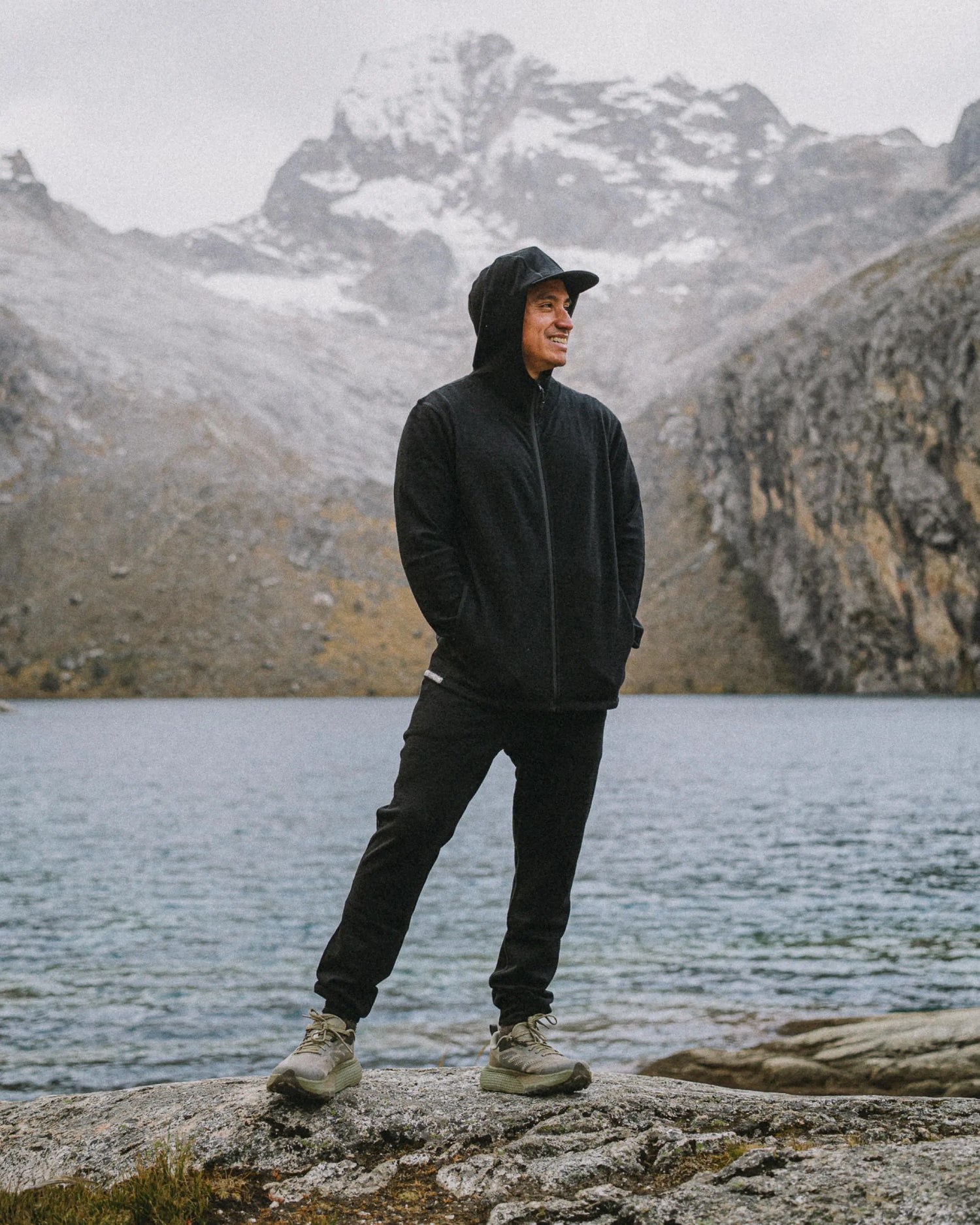 Three-quarter view of Men’s Breathe Joggers in black showing tapered fit and ankle cuffs in alpaca terry on a model by a mountain lake