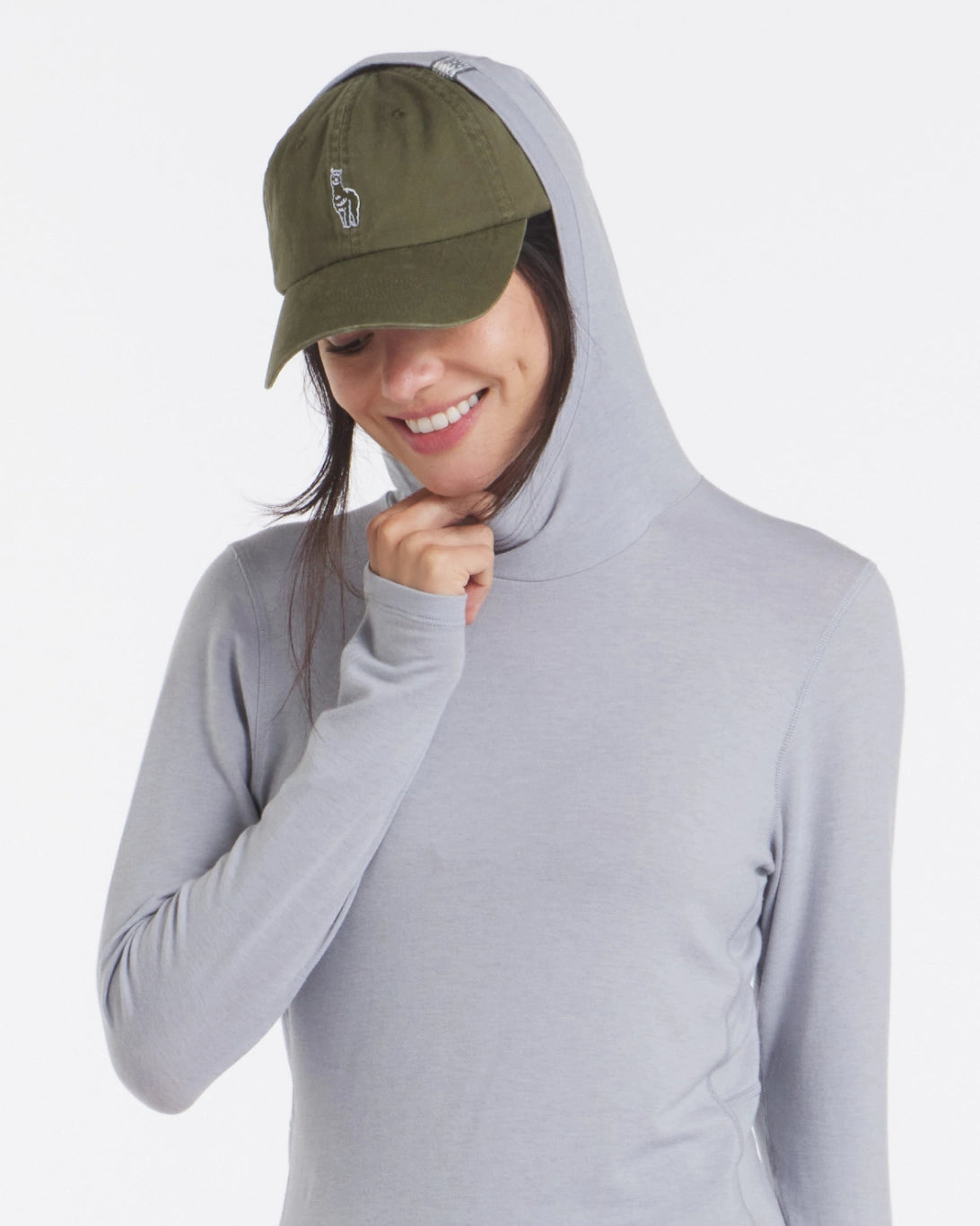 Three-quarter view of Women’s Sol Hoodie in Supernova grey showing hood up and hidden thumbhole on model against white background