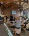 Group of young women and PAKA staff gathered in an indoor meeting room during a scholarship visit