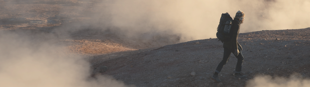 Person wearing Aire Long Sleeve base layer standing on a rocky outcrop in early morning fog at sunrise