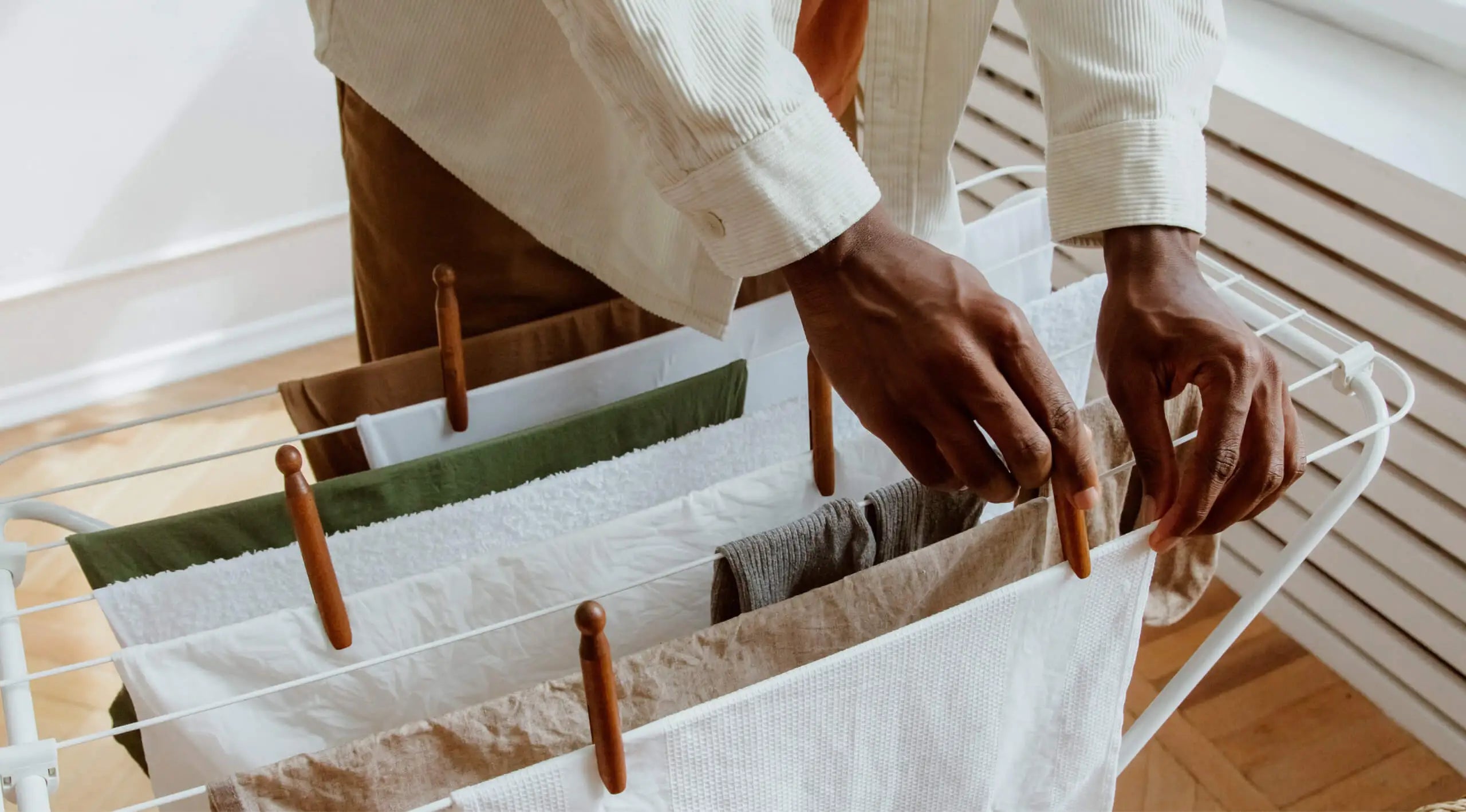 Someone placing clothes on a rack to air-dry