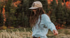 A smiling girl wearing The Crew outdoors.
