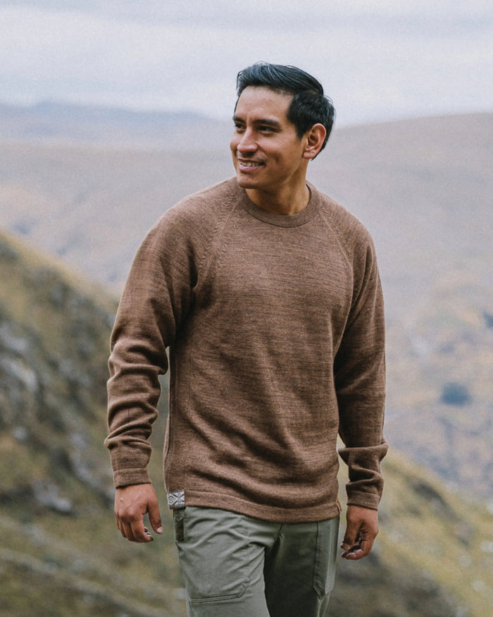 Side-front view of The Original Crew alpaca crewneck showing relaxed fit and raglan sleeves in a mountain landscape
