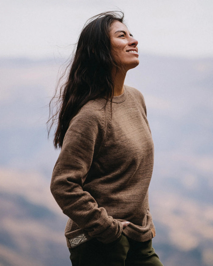 Three-quarter view of The Original Crew alpaca crewneck sweater in cafe heather showing relaxed fit and raglan sleeves with mountain background