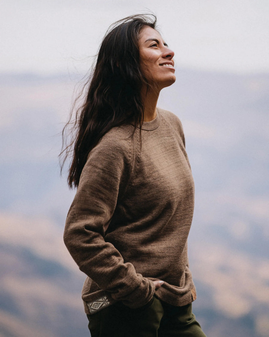 Three-quarter view of The Original Crew alpaca crewneck sweater in cafe heather showing relaxed fit and raglan sleeves with mountain background