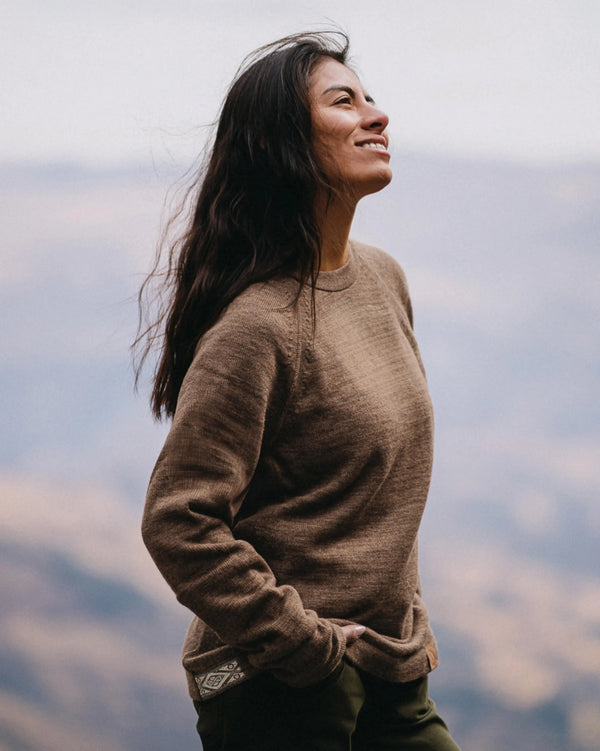 Three-quarter view of The Original Crew alpaca crewneck sweater in cafe heather showing relaxed fit and raglan sleeves with mountain background
