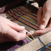Hands of a Quechua woman weaving colorful blanket