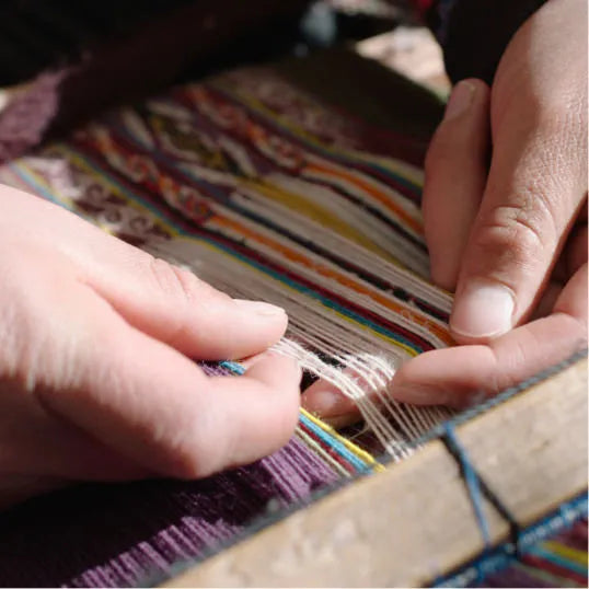 Hands of a Quechua woman weaving colorful blanket