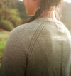 Back view of ultralight alpaca-blend sweater showcasing shoulder seam and fine knit texture with soft outdoor background