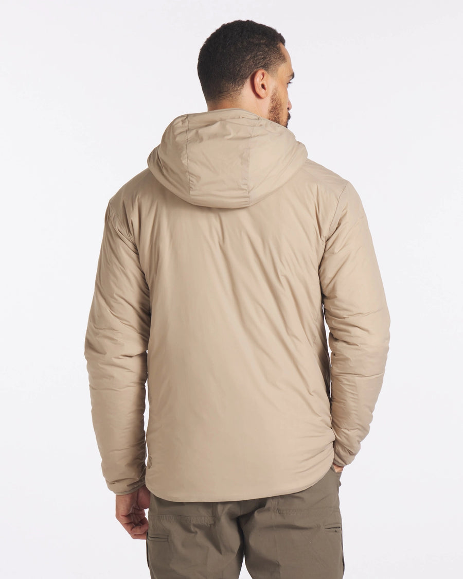 Rear view of Men’s Apu Lightweight Puffer jacket in tan showcasing hood and lightweight fitted silhouette on model against white background