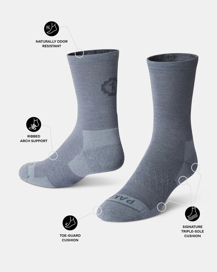 Three-quarter view of Essential Crew Socks in indigo showing toe guard, ribbed arch support, and naturally odor resistant callouts