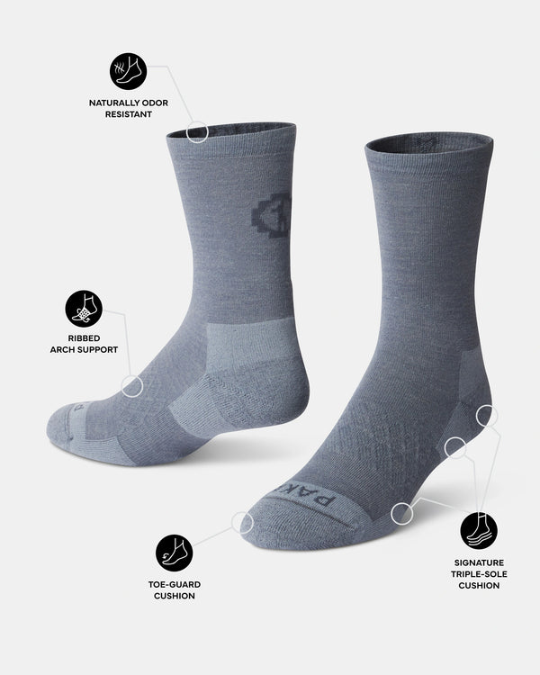 Three-quarter view of Essential Crew Socks in indigo showing toe guard, ribbed arch support, and naturally odor resistant callouts