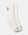 Top view of Essential Crew Socks showcasing white alpaca crew socks with black PAKA logo at toe and cuff on light gray background