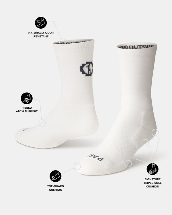 Three-quarter view of Essential Crew alpaca socks showing ribbed arch support, toe-guard cushion, triple-sole cushion, and PAKA logo on white background