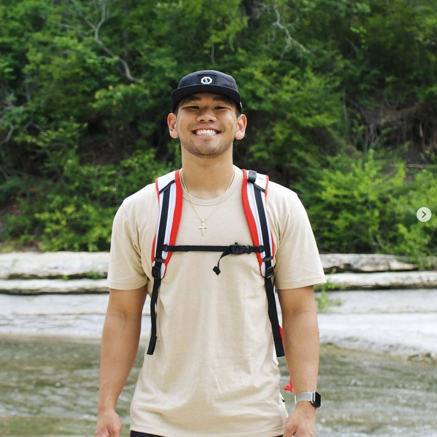 Man Smiling in a Sandstone / Tan Natural Alpaca Fiber T-Shirt by a River and Greenery – PAKA Apparel