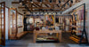 Flagship store interior with clothing displays, café counter, wooden beams, and seating area showcasing Andean textiles