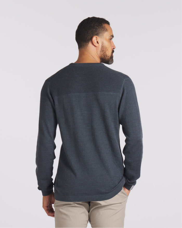Rear view of The Lightweight Crew alpaca crewneck in charcoal showing textured yoke and relaxed fit on model