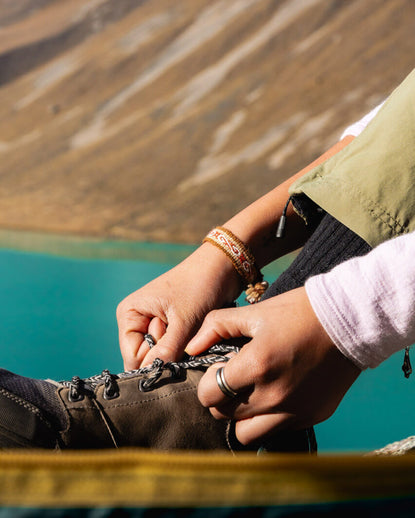 Someone tying their shoes and wearing one of our alpaca bracelets