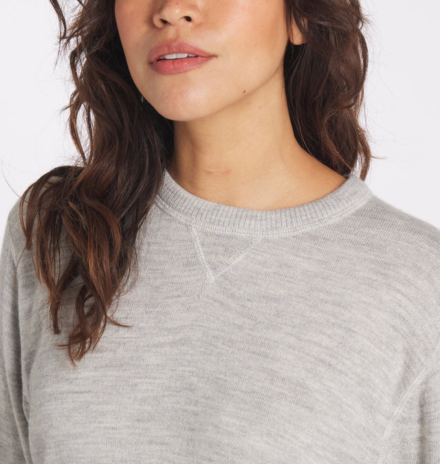 Front close-up of light heather gray Ultralight Crew on model showing rib-knit crew neck and V-stitch detail, white background