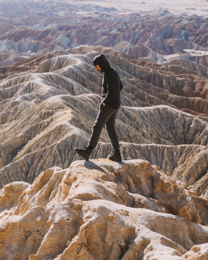 Man Named Rod in The Hoodie Charcoal / Dark Grey Hooded Sweater Hiking over Mountainous Terrain – PAKA Apparel