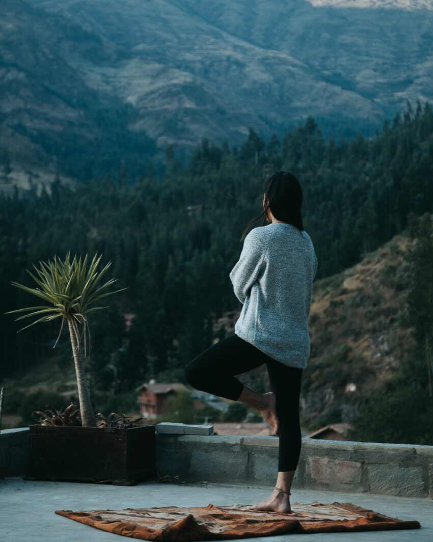 A woman looking at the nature doing a yoga pose