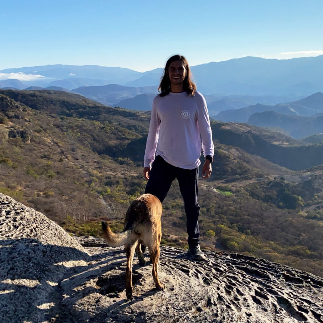 A guy on his lavender Sebastian Baselayer and his dog in the mountains