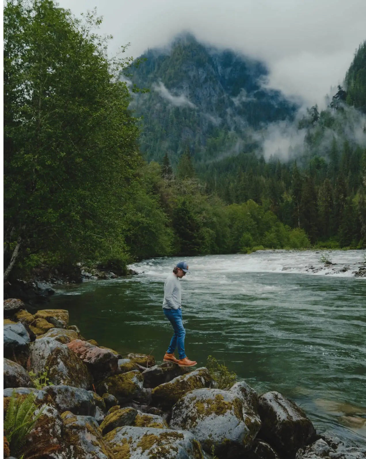 Man Named Mio Walking on Rocks by a River in Heather Grey Aire Lightweight Long Sleeve Shirt – PAKA Apparel