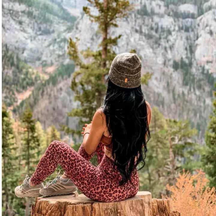 A woman wearing an alpaca beanie looking at the mountains