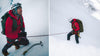 Mountaineer rappelling down a steep snowy slope while anchored to a rope, wearing a red jacket, helmet, backpack, and crampons