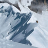 Mountaineer traversing a snow ridge on Yanapaccha with steep cornices and cloudy peaks in the Cordillera Blanca, Peru