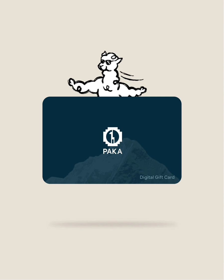 Front view of PAKA digital gift card showing white PAKA logo over a dark blue mountain graphic, ‘Digital Gift Card’ text, and a cartoon alpaca above on a beige background
