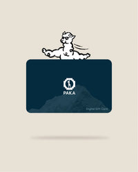 Front view of PAKA digital gift card showing white PAKA logo over a dark blue mountain graphic, ‘Digital Gift Card’ text, and a cartoon alpaca above on a beige background