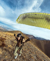 Hiker wearing Mayu ultralight PAKAFILL jacket preparing to paraglide on a windswept hillside