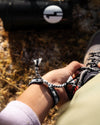 Woman Arm Adjusting Boot Laces Wearing Mayu Grey Handwoven Quechua Alpaca Bracelet – PAKA Apparel