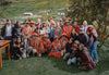 PAKA team and Quechua weavers pose together in a grassy Peruvian highland village