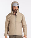 Three-quarter view of tan Apu Lightweight Puffer worn on model, showing quilted insulation and chest zip pocket