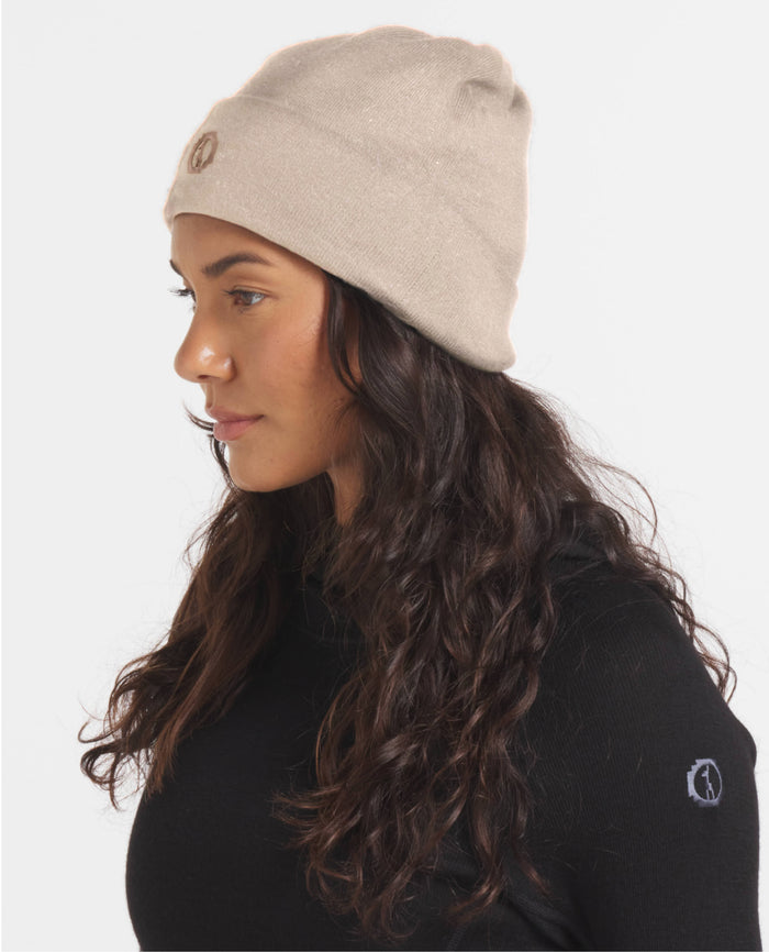 Side view of cuffed beanie showing embroidered logo and rib-knit alpaca wool in timber beige on model
