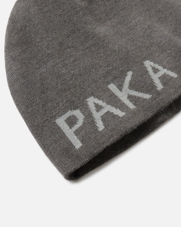 Close-up of skull cap beanie showcasing jacquard PAKA logo on gunmetal grey alpaca knit against white background