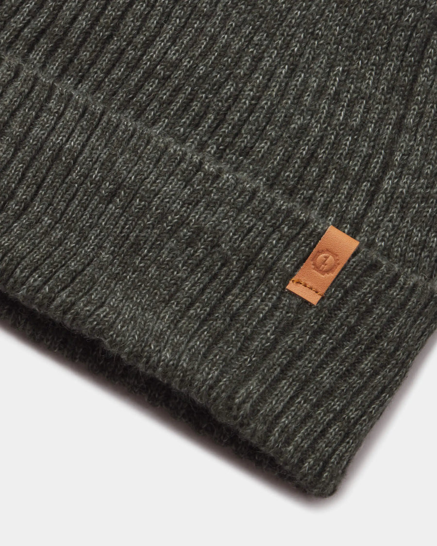 Cozy Marled Beanie in Andean Moss  with a brown leather PAKA label on a white background