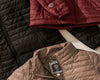 Model wearing Mayu ultralight jacket with PAKAFILL insulation standing on a windswept mountain ridge