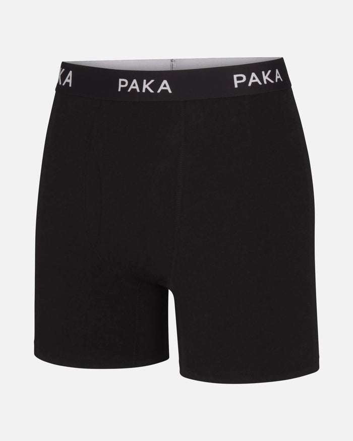 Front view of Essential Boxer Brief in black with PAKA elastic waistband and mid-thigh length on white background