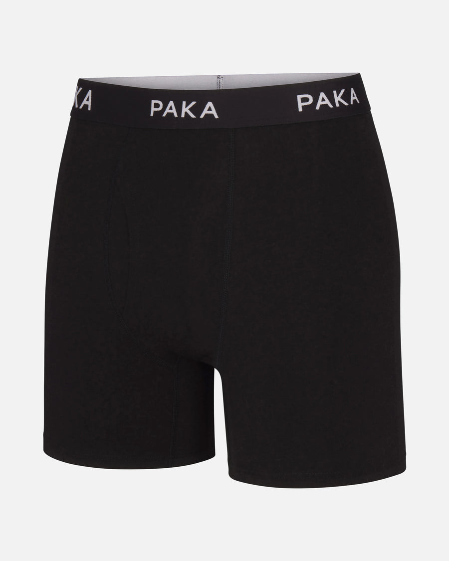 Front view of Essential Boxer Brief in black with PAKA elastic waistband and mid-thigh length on white background