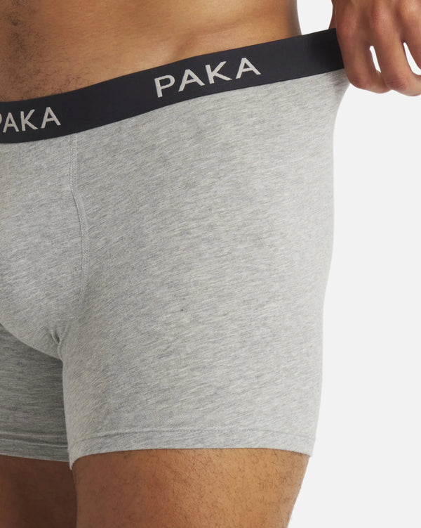 Side view of Men’s Essential Boxer Brief in heather grey showcasing PAKA branded waistband and mid-thigh coverage on white background