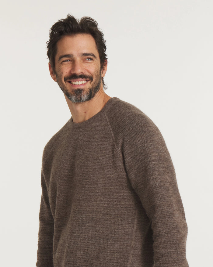 Three-quarter view of Men’s Mountain Crew sweater with raglan sleeves and heathered wood-brown knit on light background