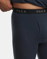 Close-up of a person wearing dark navy ribbed compression or athletic leggings with a black waistband featuring the brand name PAKA in white.