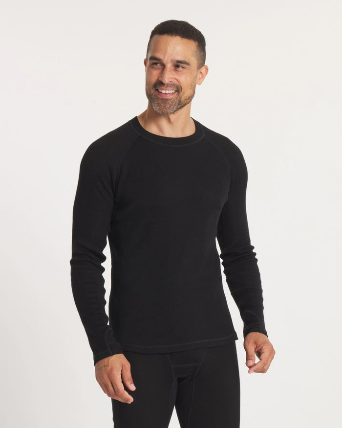 Front three-quarter view of men’s black alpaca thermal crew baselayer, slim fit with raglan sleeves on white background