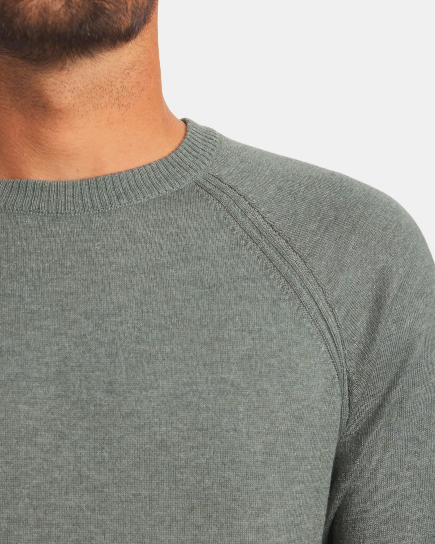 Close-up of Men’s Ultralight Crew in lichen showcasing ribbed crewneck and raglan shoulder seam with light gray background