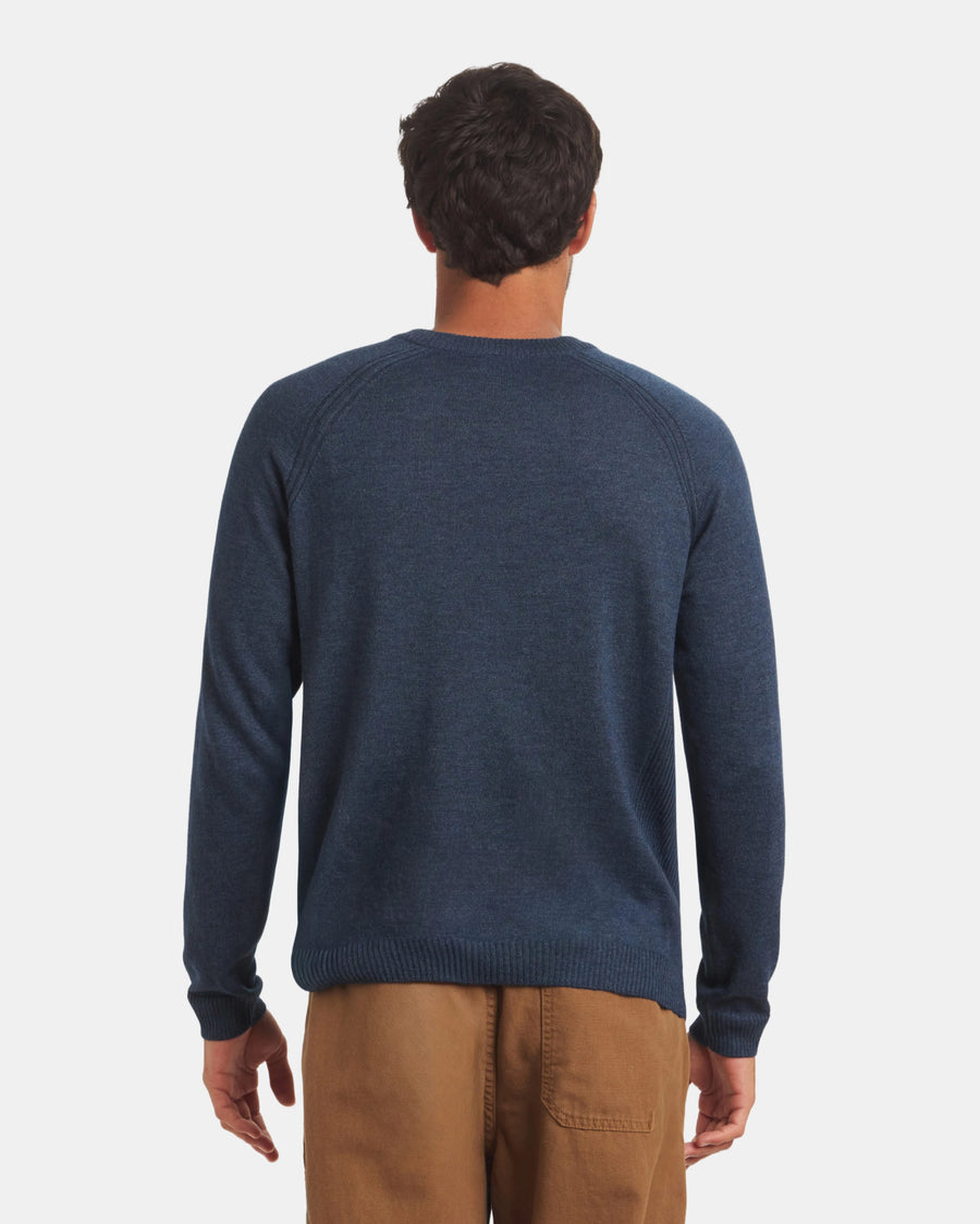 Back view of Men’s Ultralight Crew in navy on model showing raglan sleeve seams and ribbed hem against a light gray background