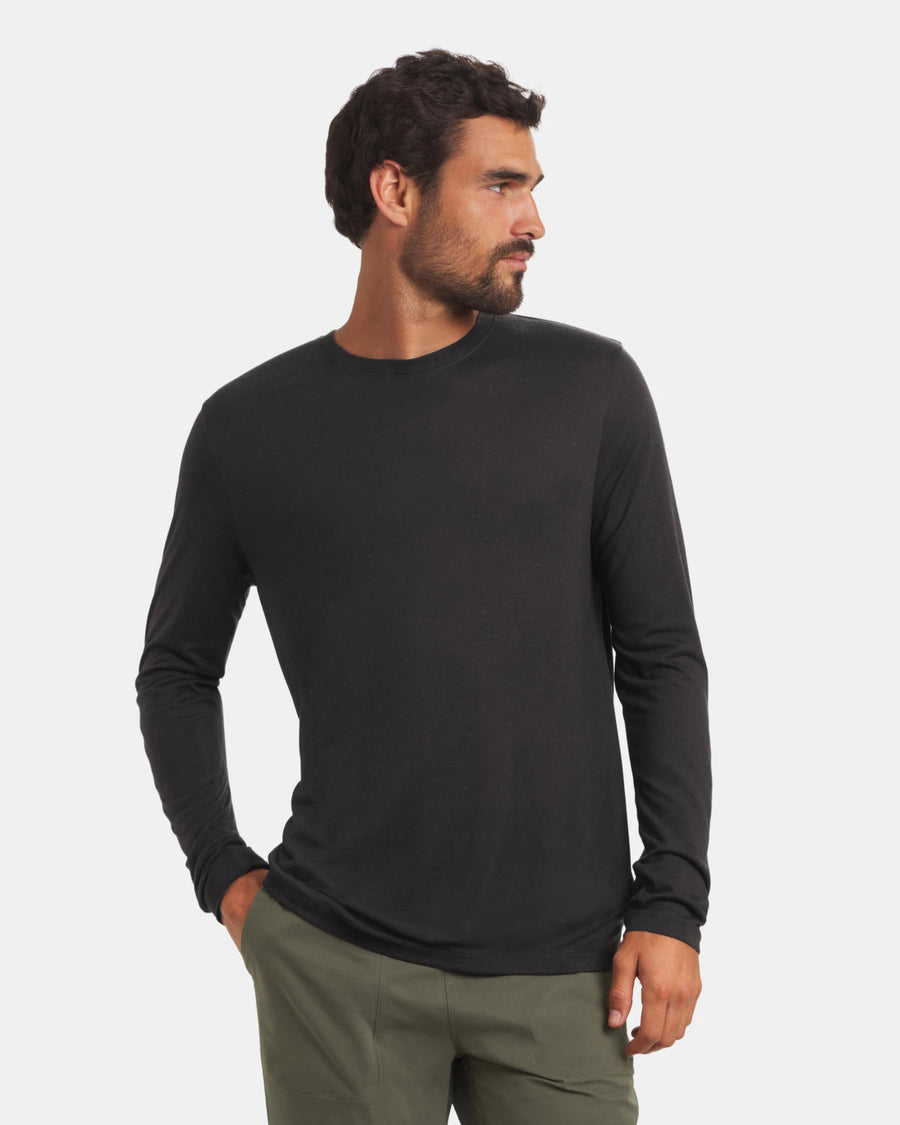 Three-quarter front view of Men’s Aire Long Sleeve shirt showcasing slim fit and crew neck in black on light gray background