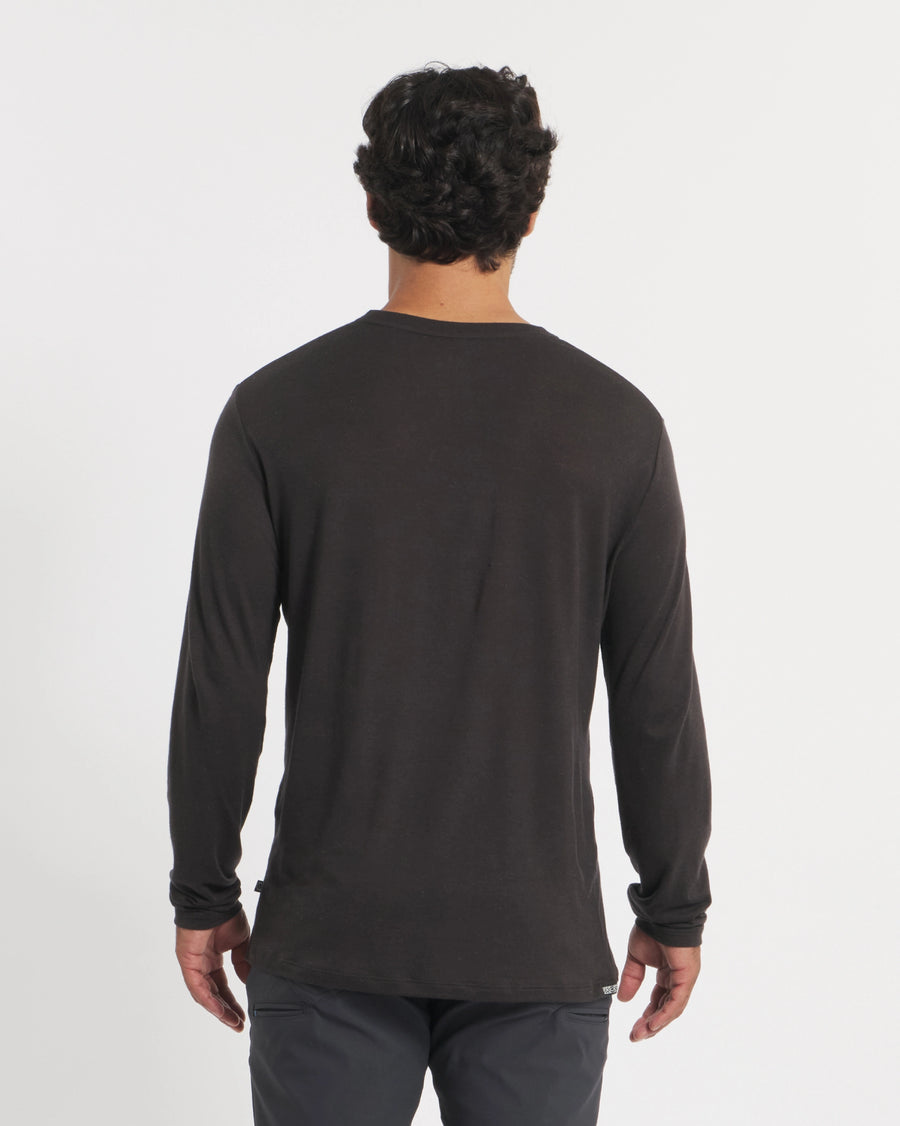 Back view of Men’s Aire long-sleeve alpaca shirt in black on model, showing relaxed fit against white background